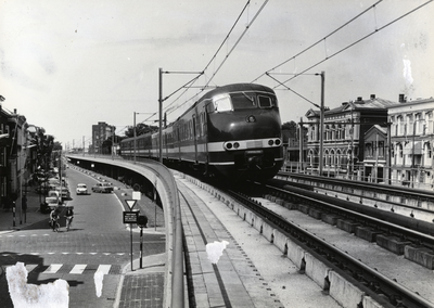 169116 Afbeelding van een electrisch treinstel mat. 1964 (plan T) van de N.S. op het viaduct van het hoogspoor door Delft.
